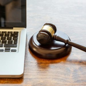 Judge gavel and a laptop, wooden background. Online auction concept